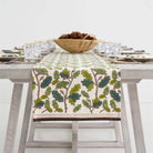 Table runner draped off side of wood table.