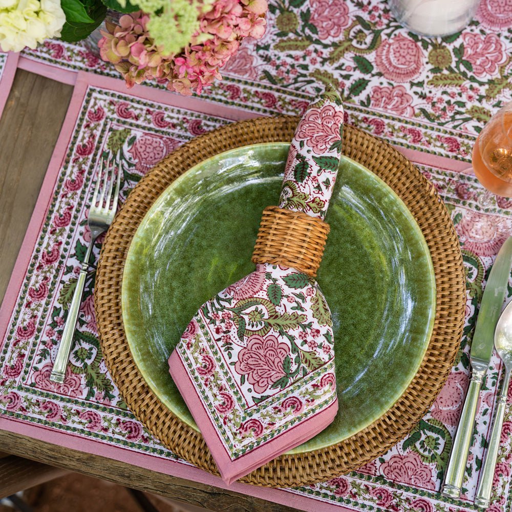 bohemian floral moss & mauve napkin with wicker napkin ring on top of green plate with wicker charger on a matching placemat