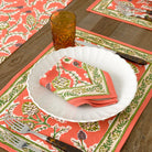 Harvest Pinecone orange & green floral napkin on white plate with matching placemat
