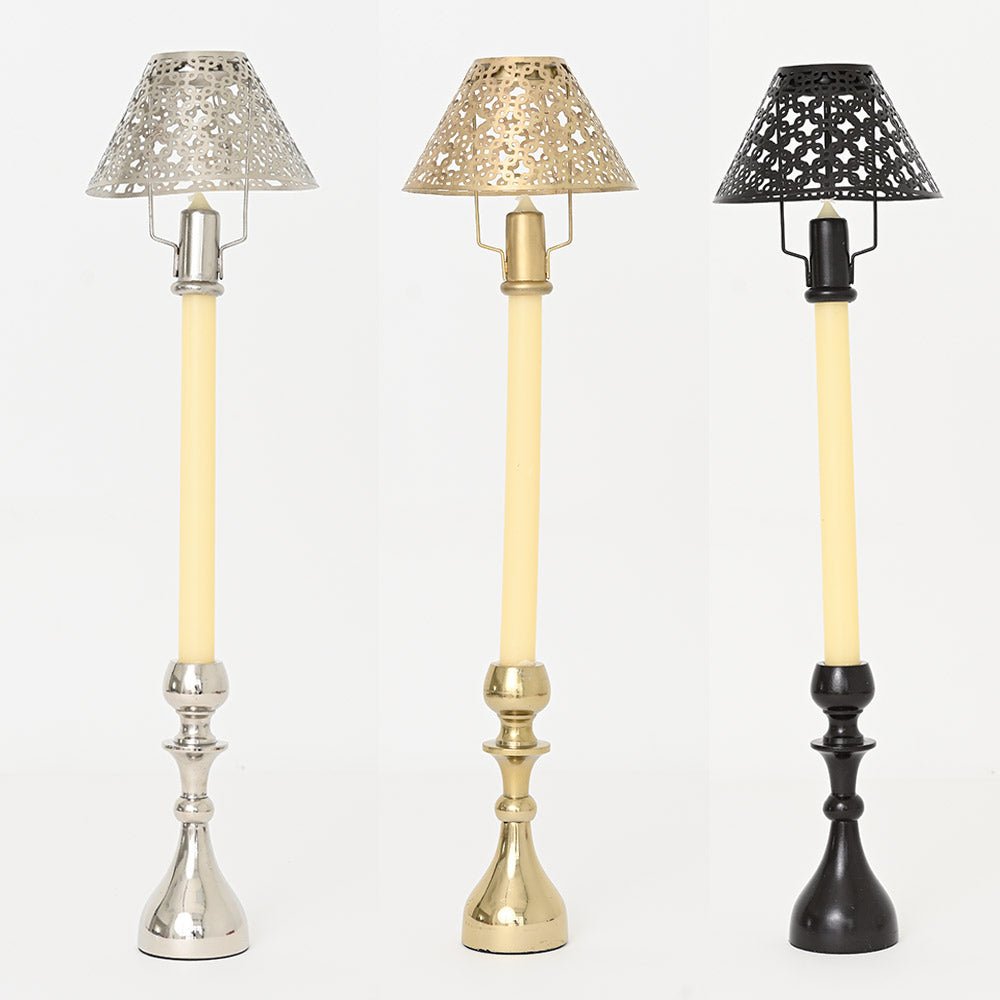 A set of three candlesticks with cutwork shades in gold, silver, and bronze colors.