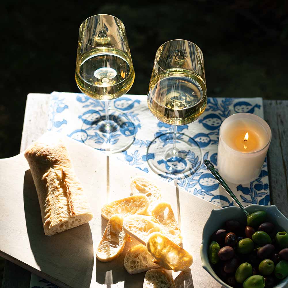 Wine and bread on table runner.