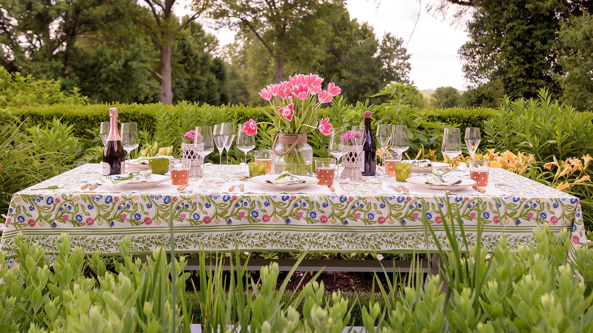 A table with a floral tablecloth and flowers in vases