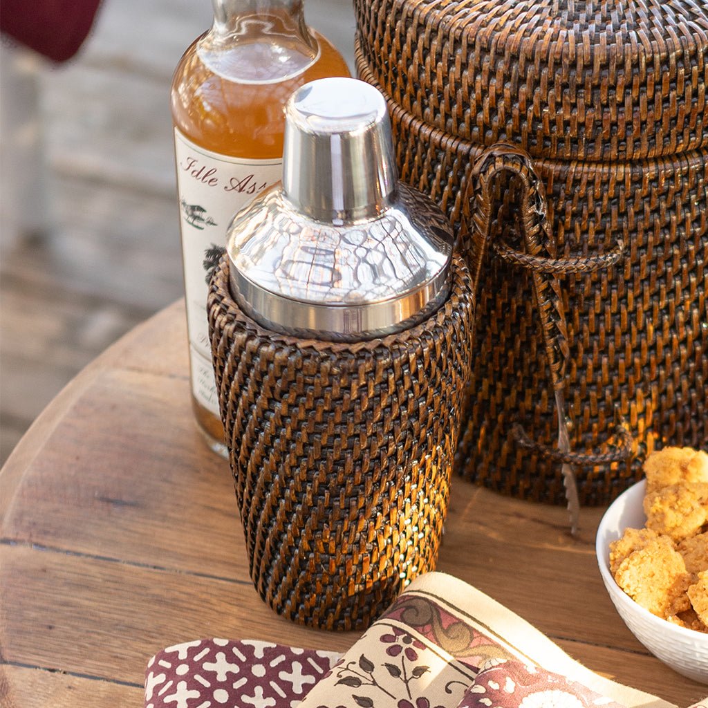 Rattan cocktail shaker on a wood table.