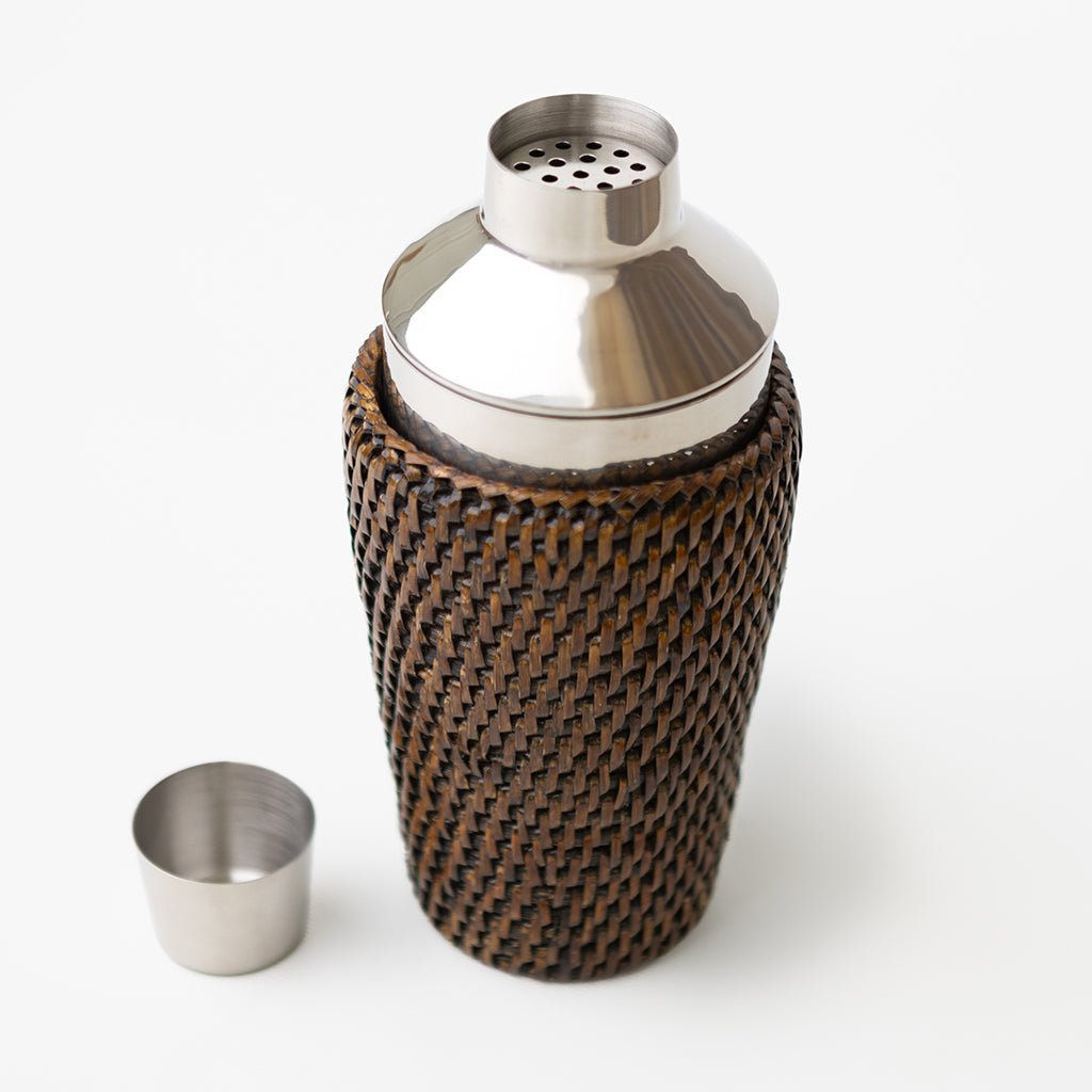 Cocktail shaker with woven design and metal top on a white background