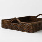 Woven brown tray with handles on a white background