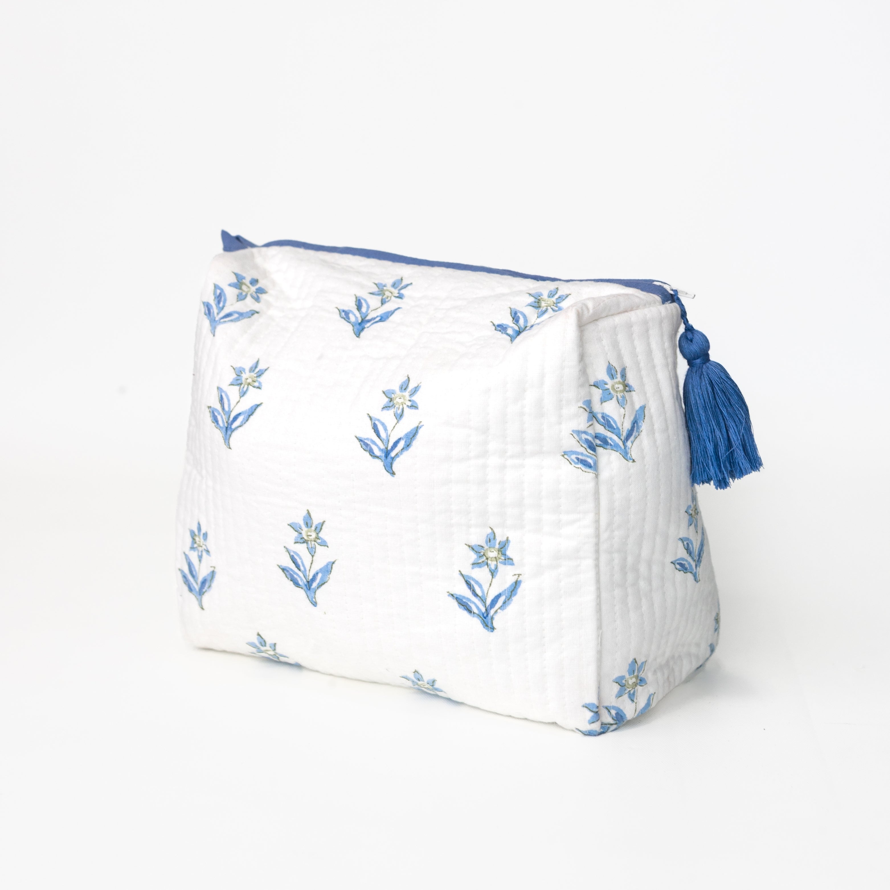 White pouch with blue floral patterns and tassel on a white background