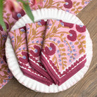 Pink floral-patterned napkins on a white plate with a wooden surface background