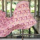 Floral patterned fabric draped over a railing with a blurred natural background