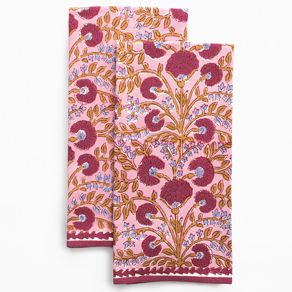 Two pink floral patterned towels on a white background