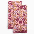 Two pink floral patterned towels on a white background