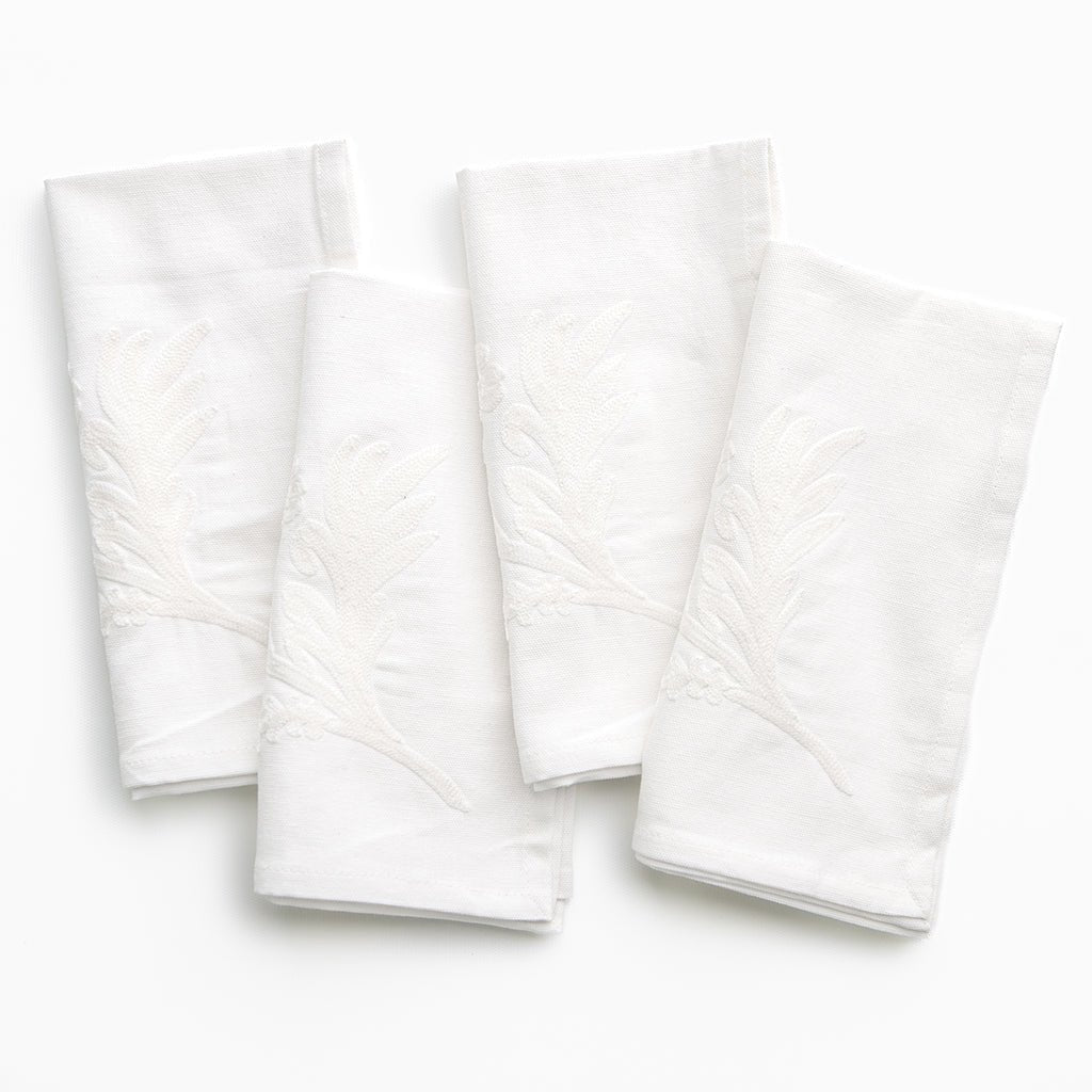 Four white textured napkins on a white background