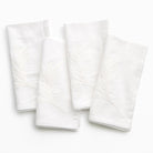Four white textured napkins on a white background