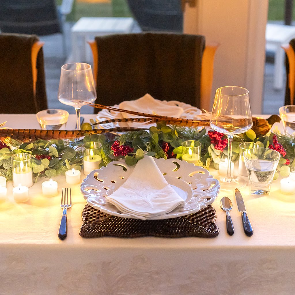 Dining table set for a meal with place settings, glasses, and decorative elements.
