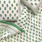 Green and white patterned bedding set on a bed