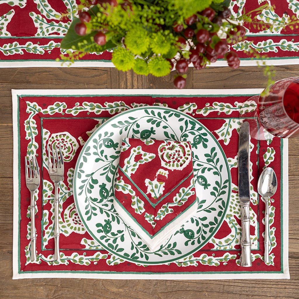 Decorative placemat with a heart design on a red background, featuring cutlery and flowers.