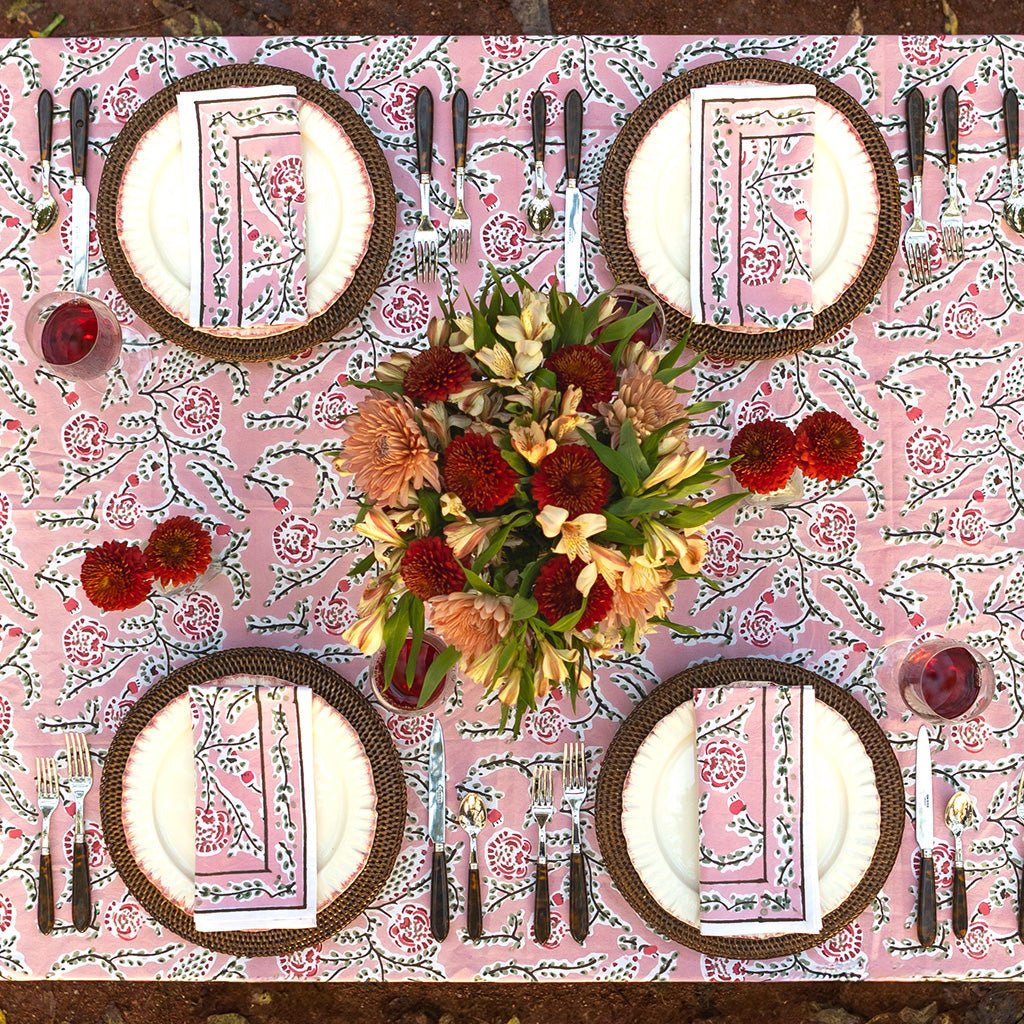 Dining table setting with floral centerpiece on a patterned tablecloth