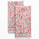 Two pink floral patterned towels on a white background