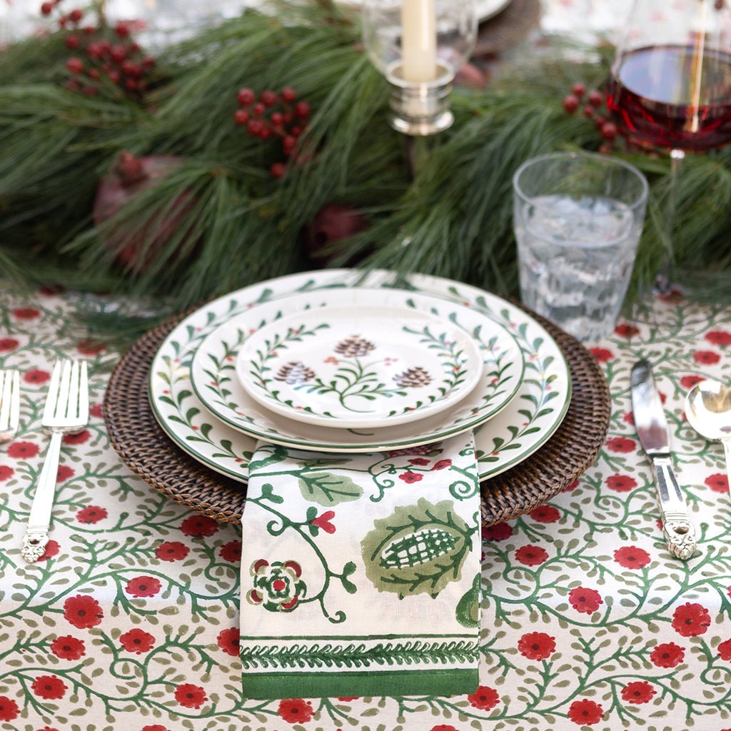 Decorative table setting with floral tablecloth, plates, and napkin.