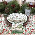 Decorative table setting with floral tablecloth, plates, and napkin.