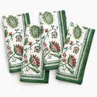Set of four napkins with green and red floral patterns on a white background