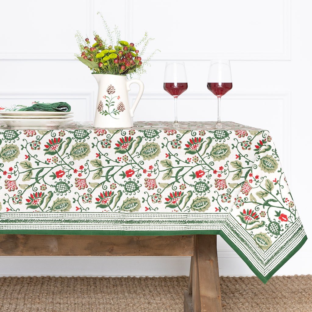 Tablecloth with floral pattern on a wooden table against a white wall