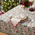 Decorative table setting with a floral tablecloth, plates, and glasses in a festive indoor setting.