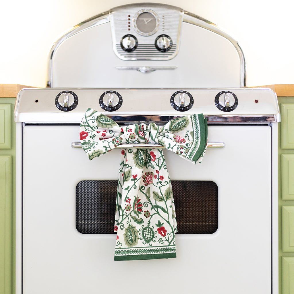 Decorative kitchen towels hanging on a vintage-style oven.