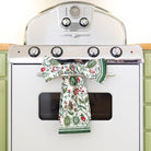 Decorative kitchen towels hanging on a vintage-style oven.