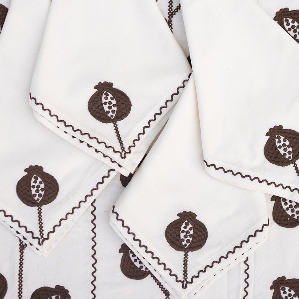 White napkins with brown pomegranate pattern on a white background