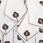 White napkins with brown pomegranate pattern on a white background