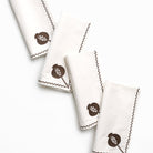 Set of white napkins with brown acorn design on a white background