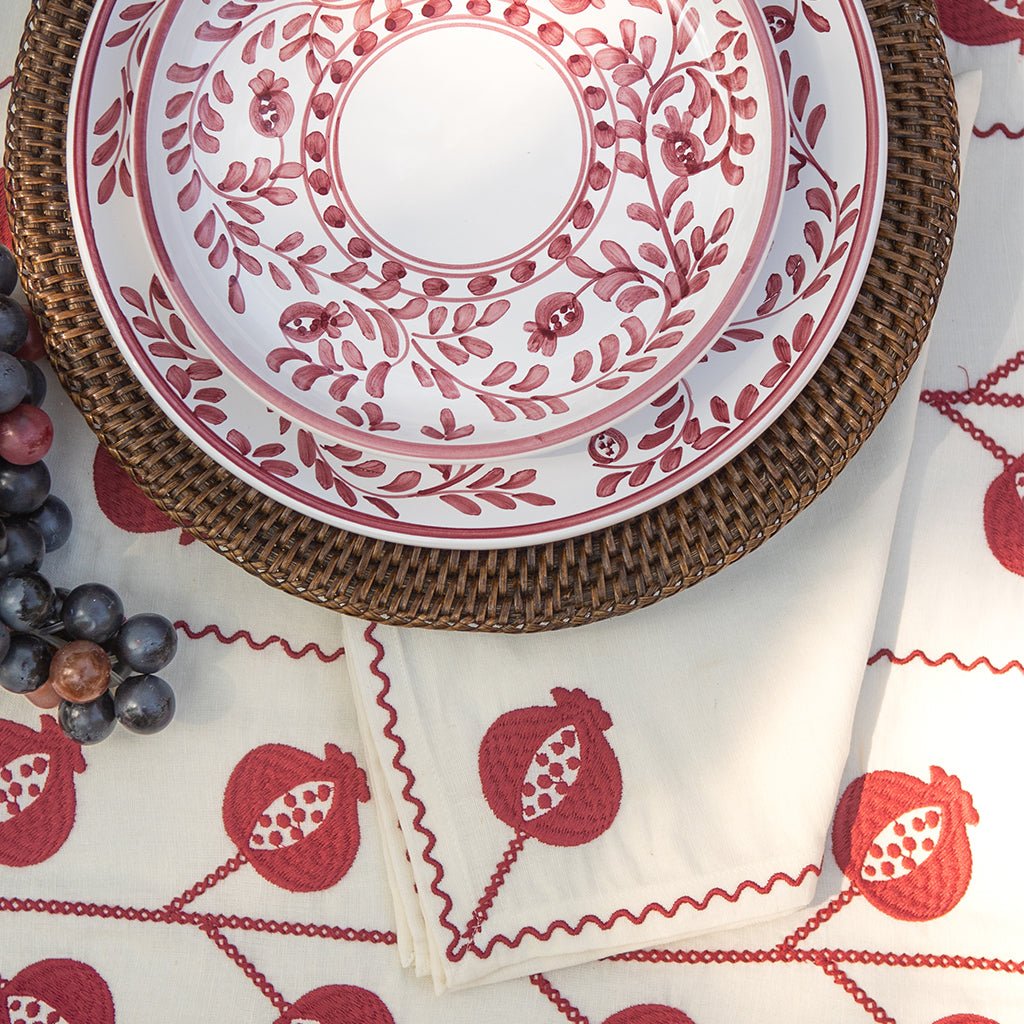 Set of red and white patterned plates and napkin on a matching tablecloth.