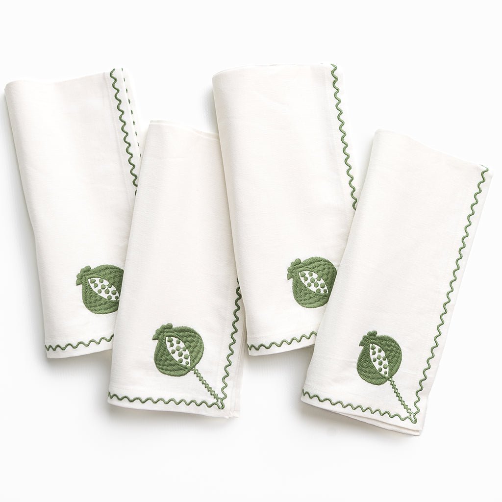 Set of four white towels with green leaf patterns on a white background