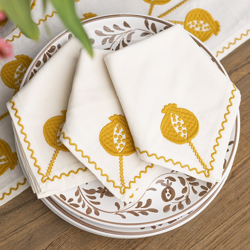 White napkins with yellow patterns on a decorative plate