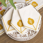 White napkins with yellow patterns on a decorative plate