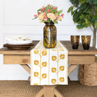 Dining table with a floral arrangement, plates, and a decorative table runner.