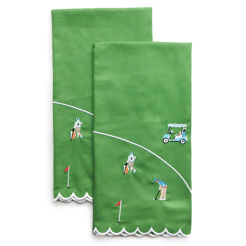 Two green towels with golf-themed designs on a white background
