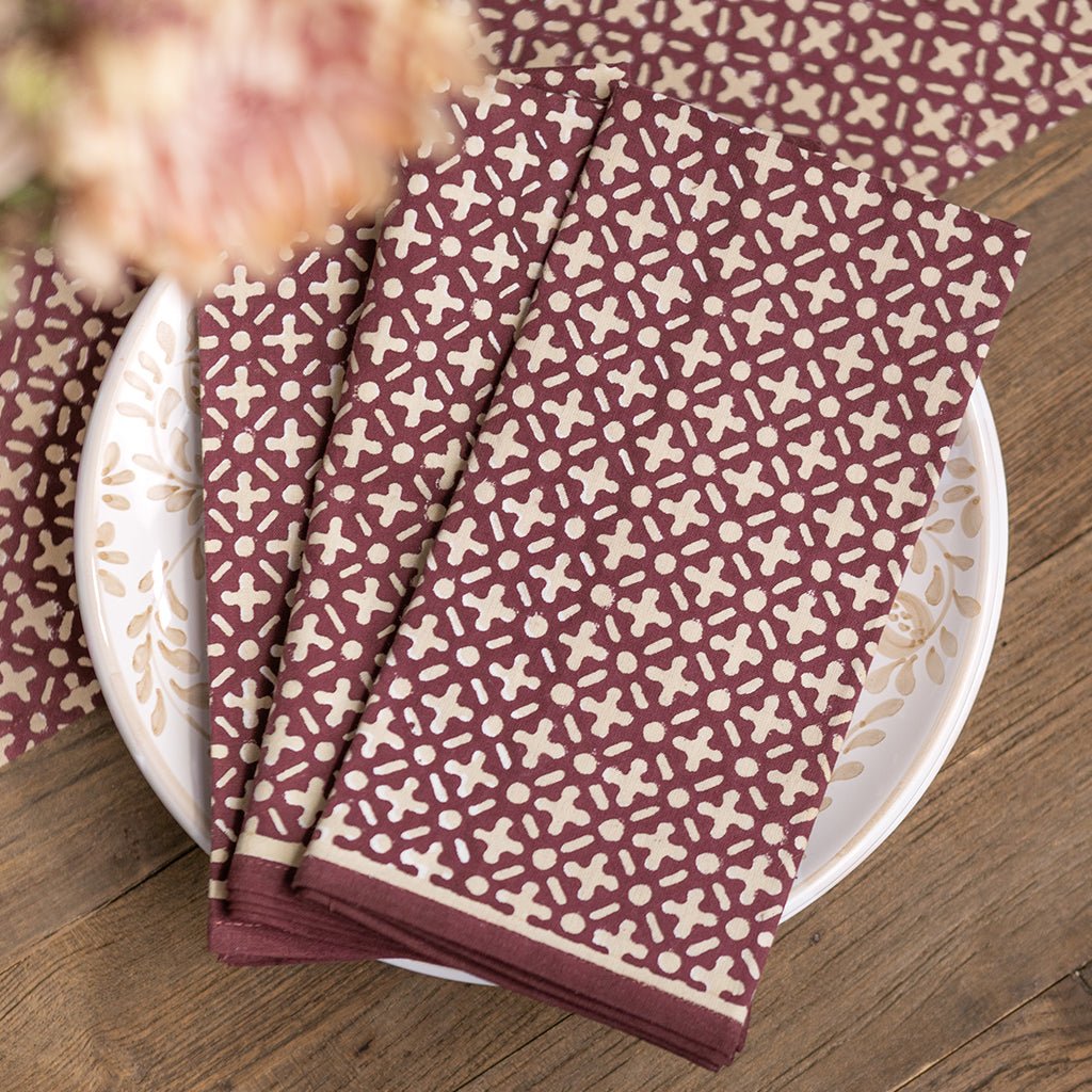 Set of patterned napkins on a white plate with a wooden background