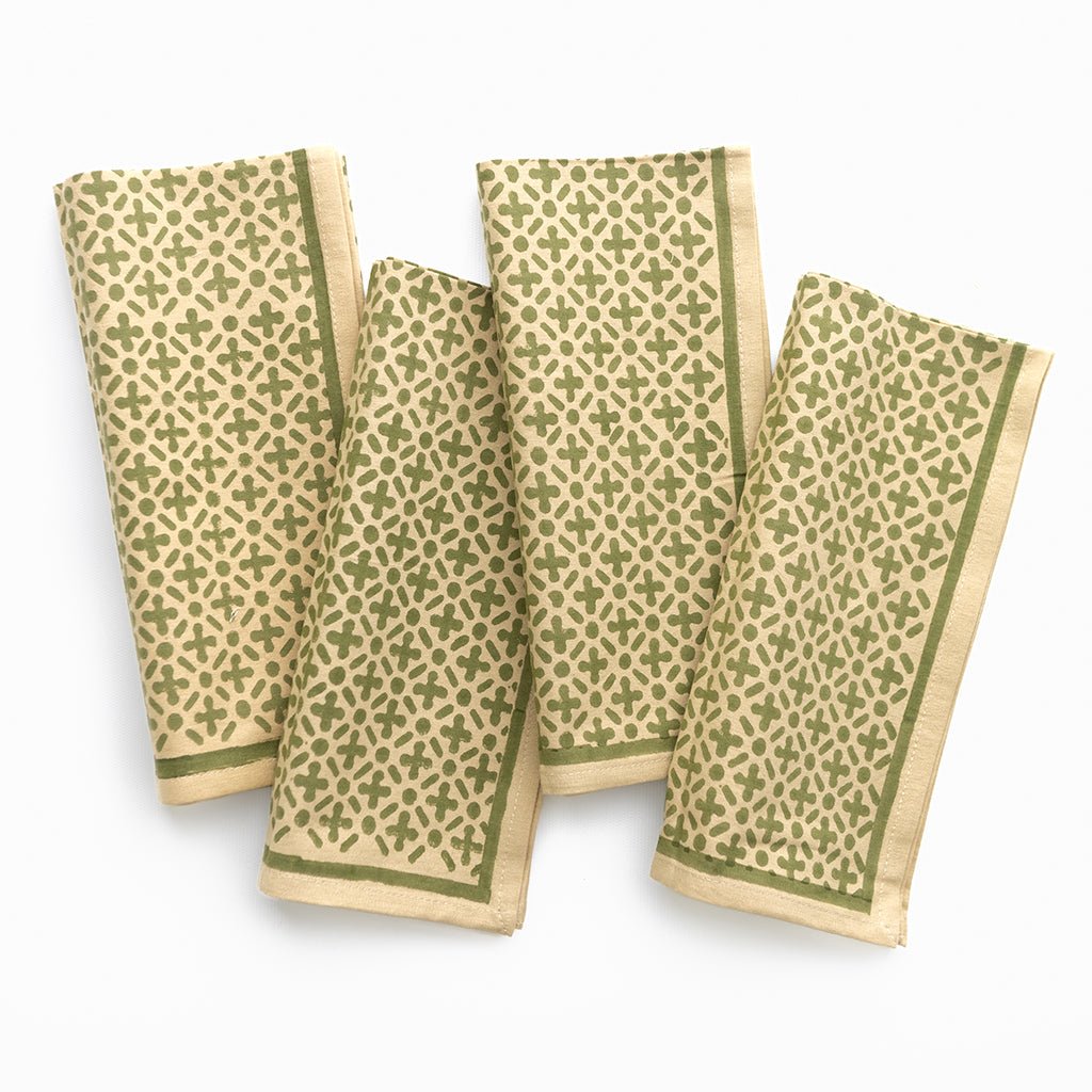 Four green patterned napkins on a white background