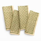 Four green patterned napkins on a white background