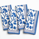 Set of four blue and white patterned napkins on a white background