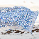 Blue floral patterned tablecloth on a sandy background
