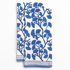 Two blue floral patterned towels on a white background