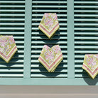 Four patterned napkins on a green slatted surface
