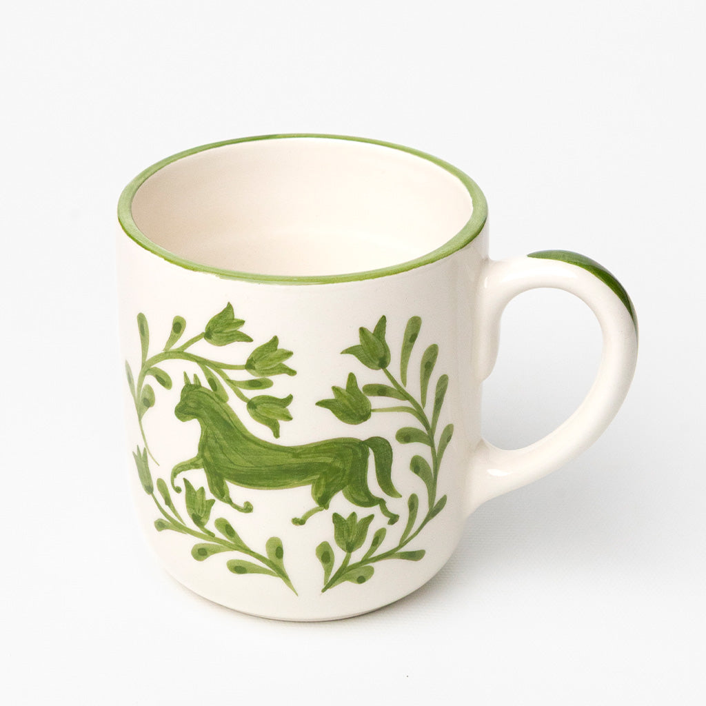 White ceramic mug with green horse and floral design.