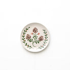 Round ceramic plate with floral design on a white background