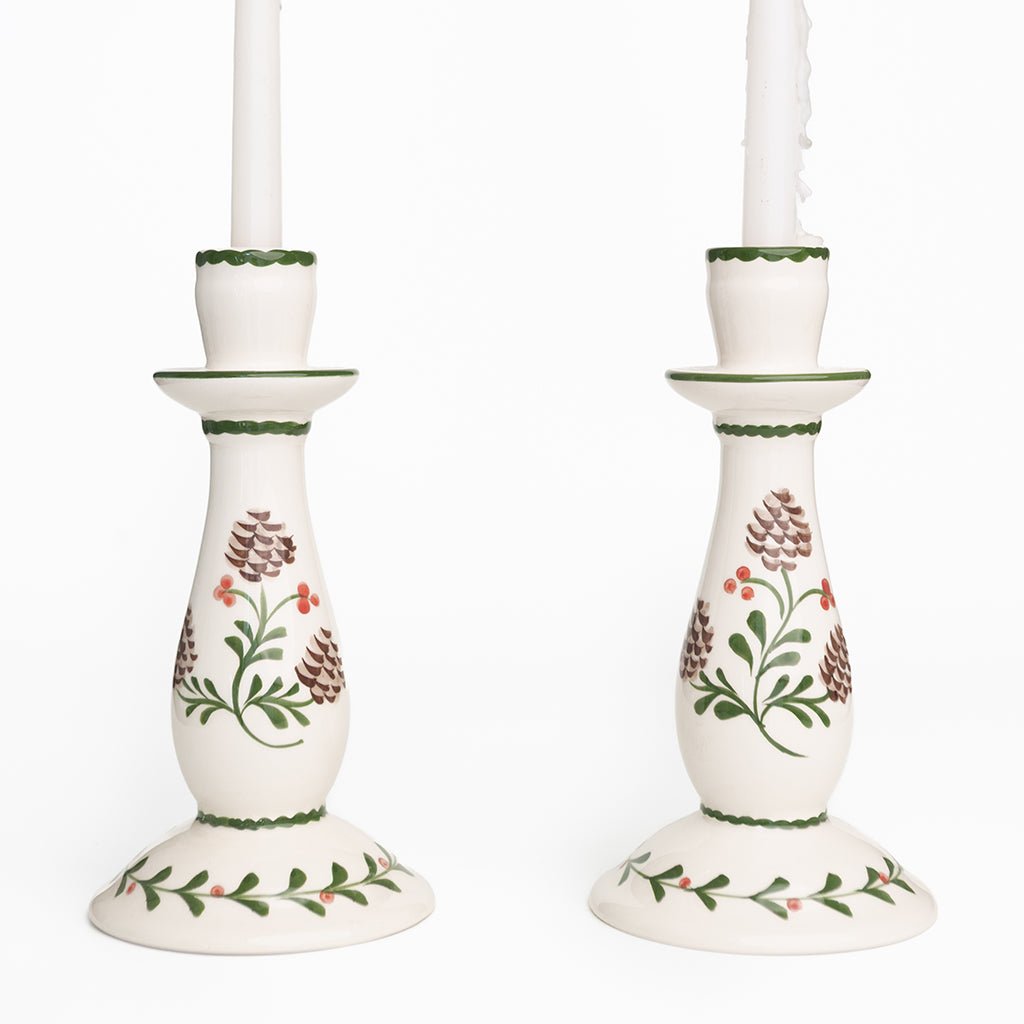 Pair of white candle holders with floral design on a white background