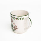 White mug with green rim and floral design on a white background