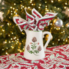 Ceramic pitcher with acorn pattern with festive background.
