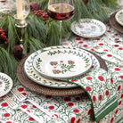 Decorative table setting with floral tablecloth, plates, and glasses.